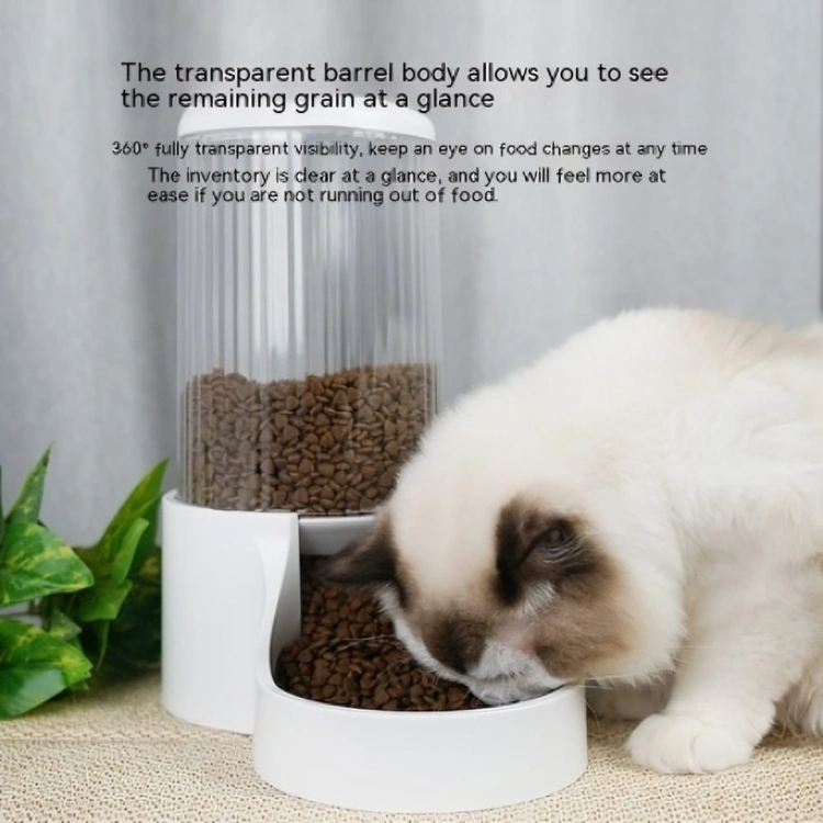 A cat is happily eating from a bowl beside an automatic pet feeder, highlighting the transparent barrel body for food visibility.