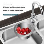 Stainless steel sink drain strainer with tomatoes, designed for residue filtering and food preparation.